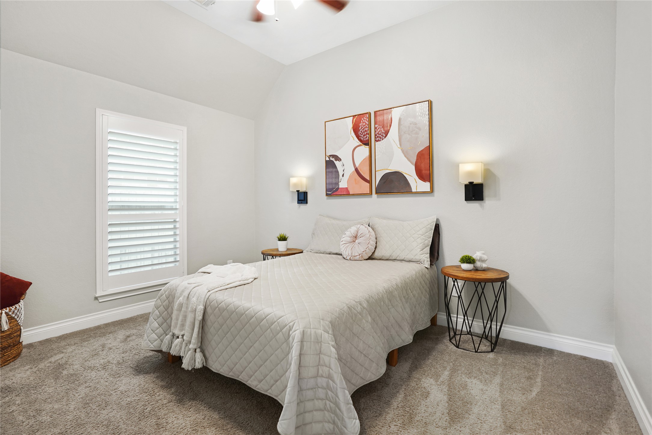 2345 Redwood Ridge Trail Manvel, TX 77578 - Photo 31 of 39 This cozy bedroom features neutral walls, a plush carpet, and a large window with shutters for natural light. It includes a comfortable bed with stylish bedding, modern wall sconces, and decorative artwork, creating a serene atmosphere.
