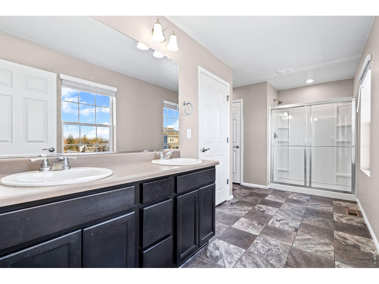 415 3rd Street Severance, CO 80550 - Photo 17 of 21 a bathroom with a sink mirror and a shower