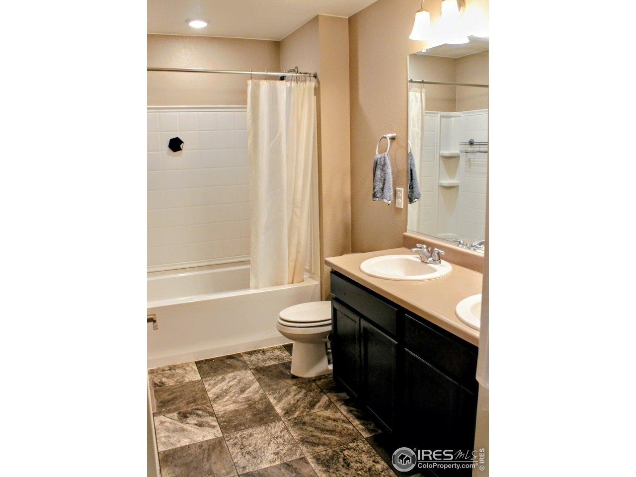 415 3rd Street Severance, CO 80550 - Photo 20 of 25 a bathroom with a double vanity sink toilet and shower