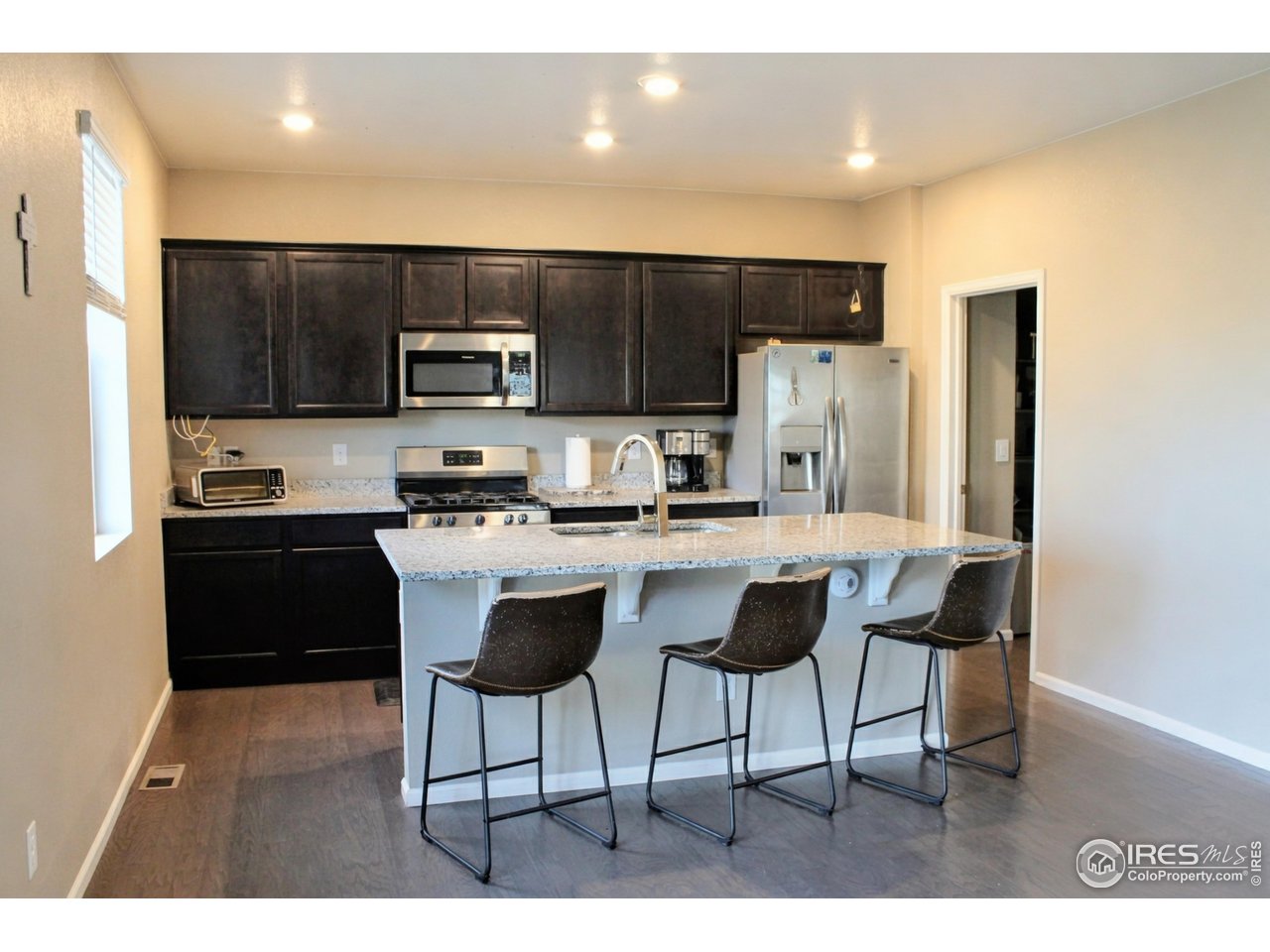415 3rd Street Severance, CO 80550 - Photo 5 of 25 a kitchen with stainless steel appliances kitchen island granite countertop a refrigerator and a stove top oven