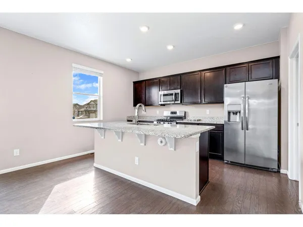 a kitchen with stainless steel appliances kitchen island granite countertop a stove a sink and a microwave