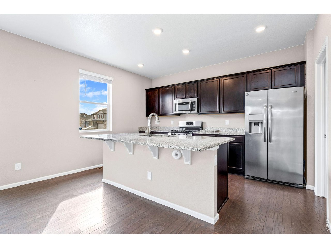 415 3rd Street Severance, CO 80550 - Photo 6 of 21 a kitchen with stainless steel appliances granite countertop a refrigerator a sink a stove a microwave a sink a refrigerator and cabinets