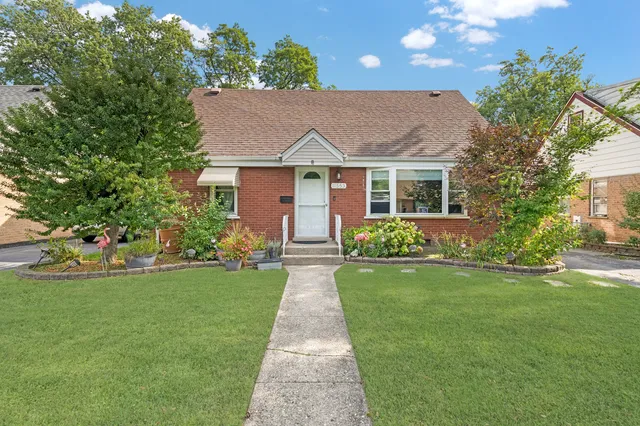 a front view of a house with a yard and potted plants