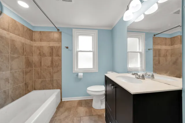 a bathroom with a sink double vanity mirror and a bathtub