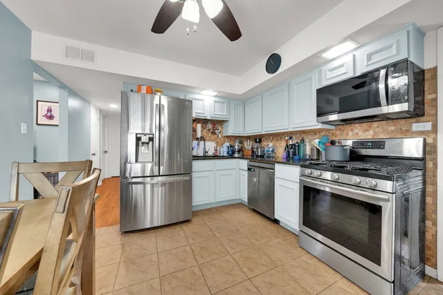 a kitchen with stainless steel appliances granite countertop a stove a microwave and a refrigerator