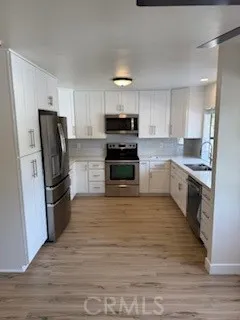 a large kitchen with a stove a refrigerator and a sink