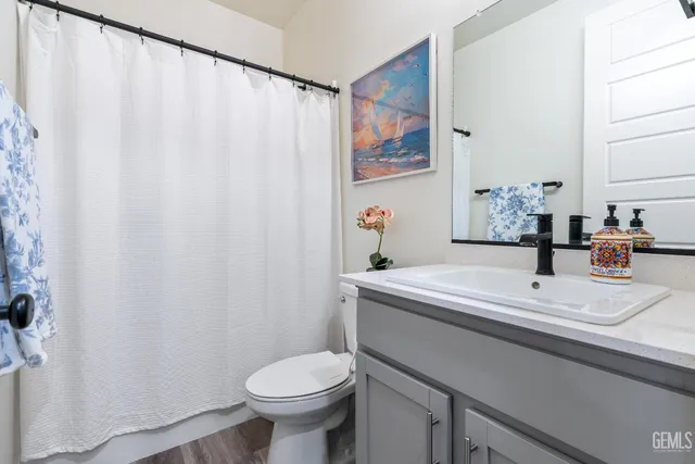 a bathroom with a sink a toilet and a mirror