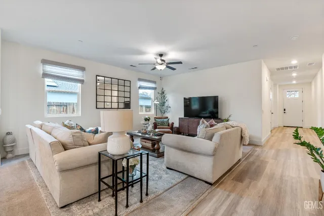 a living room with furniture a flat screen tv and a large window