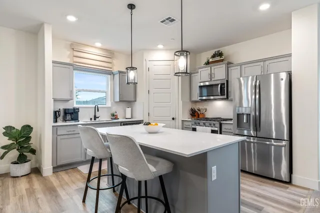 a kitchen with refrigerator a sink and chairs