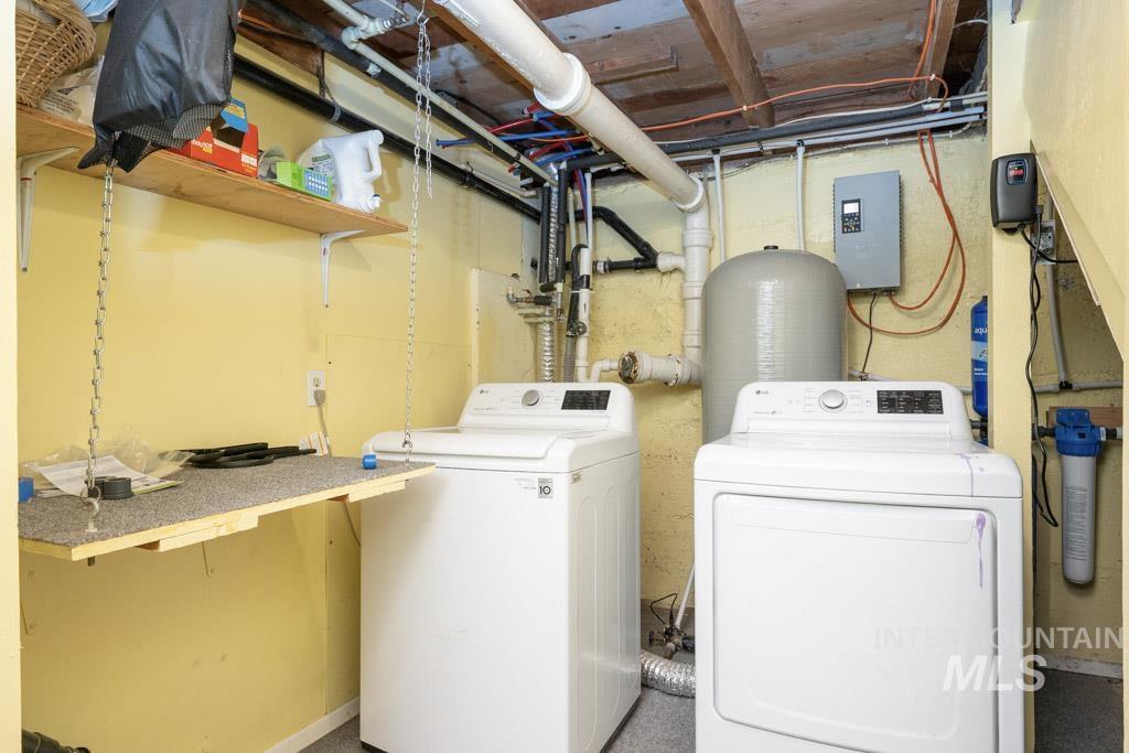 259 Highway 12 Pomeroy, WA 99347 - Photo 33 of 45 Dedicated laundry area featuring a washer and dryer, exposed ceiling joists, overhead shelving, and a water filtration system