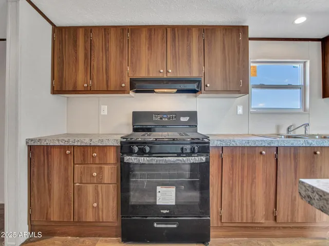 a kitchen with stainless steel appliances granite countertop a sink stove and cabinets