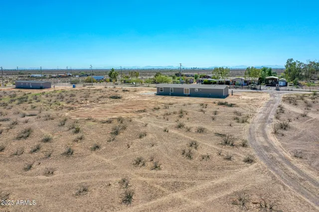 a view of a dry yard with wooden fence