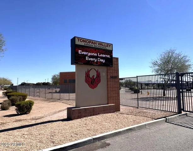 a bathroom with a granite countertop sink a toilet and a mirror
