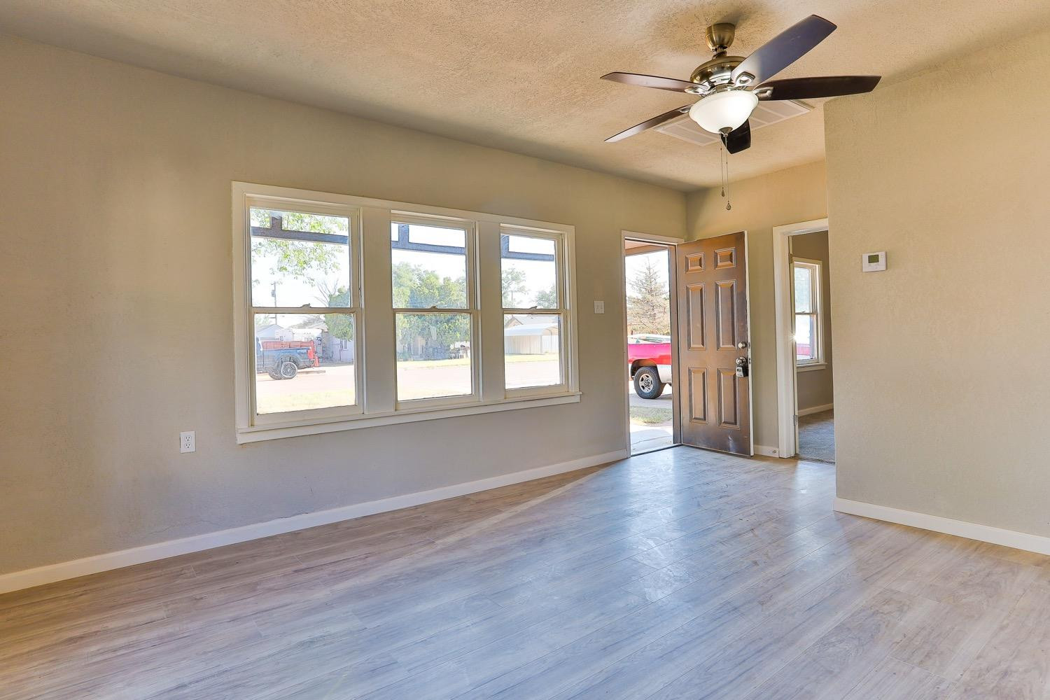 435 West Lynn Street Slaton, TX 79364 - Photo 1 of 22 a view of an empty room with wooden floor and a window