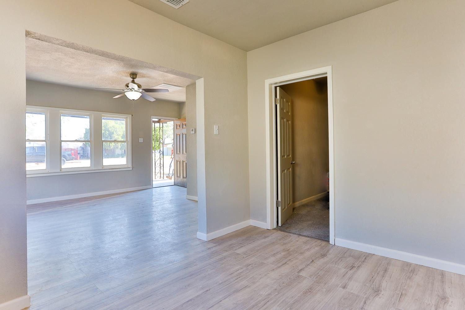 435 West Lynn Street Slaton, TX 79364 - Photo 11 of 22 a view of an empty room with window and wooden floor