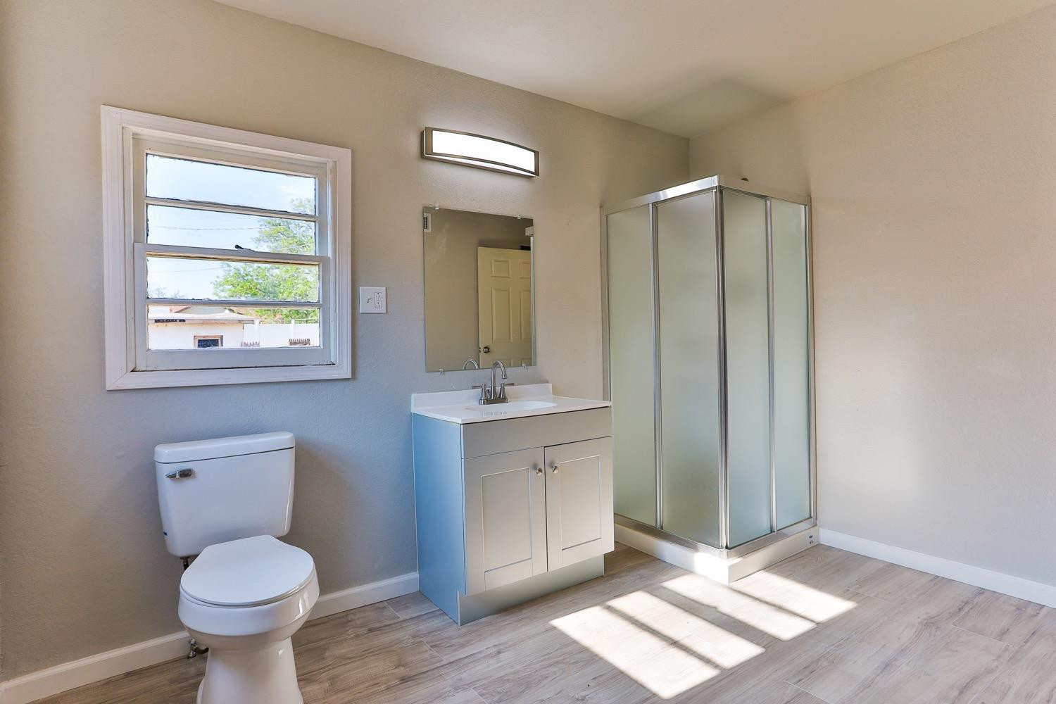 435 West Lynn Street Slaton, TX 79364 - Photo 13 of 22 a bathroom with a toilet sink and mirror
