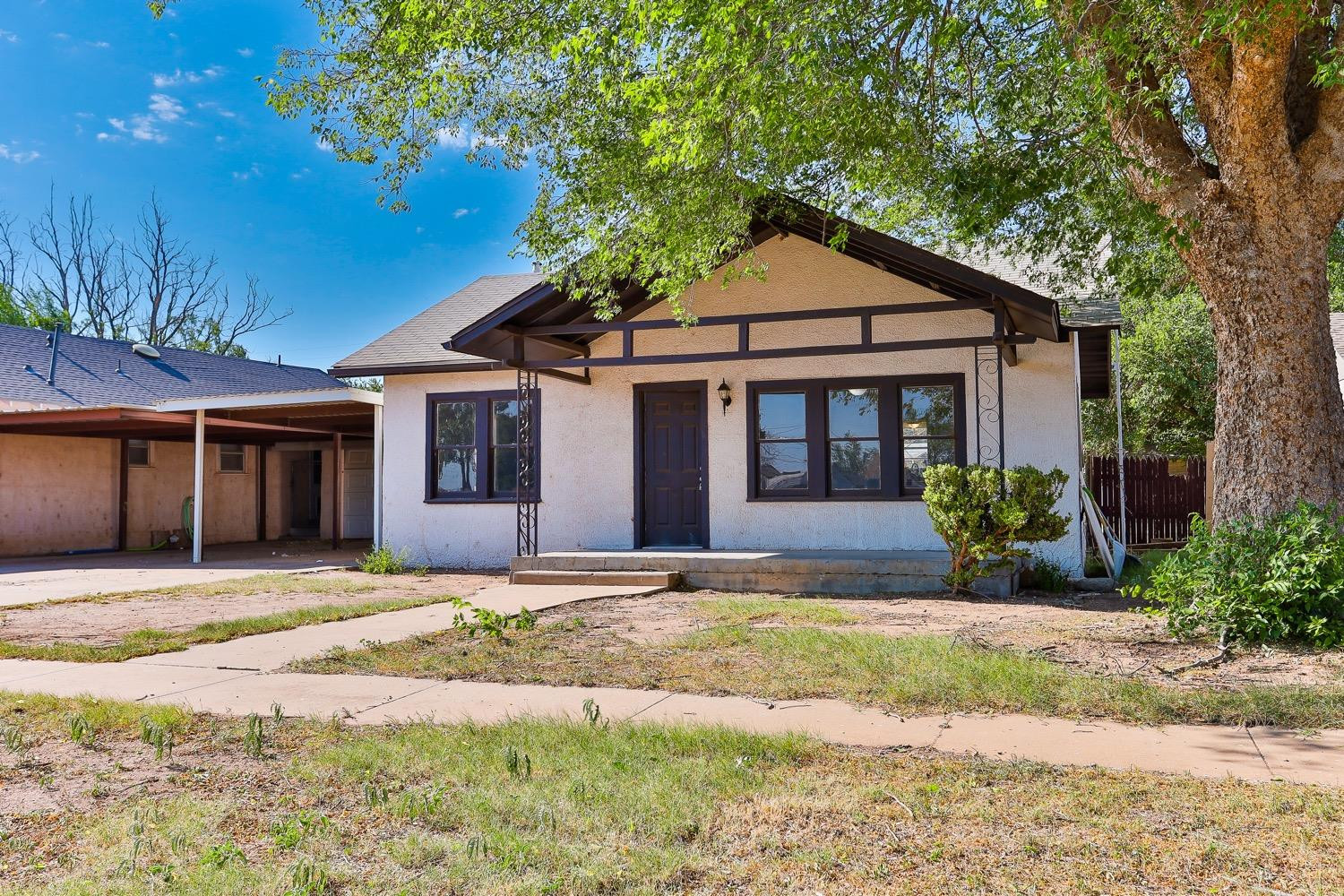 435 West Lynn Street Slaton, TX 79364 - Photo 19 of 22 a front view of a house with a yard and potted plants
