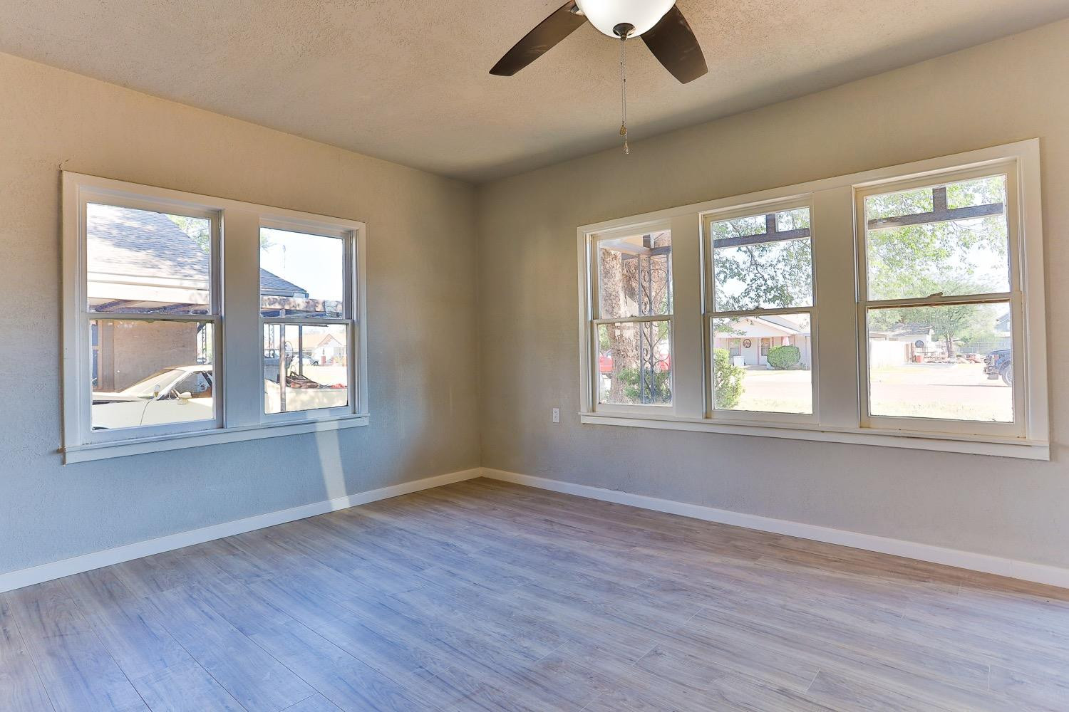 435 West Lynn Street Slaton, TX 79364 - Photo 2 of 22 a view of an empty room with wooden floor and a window