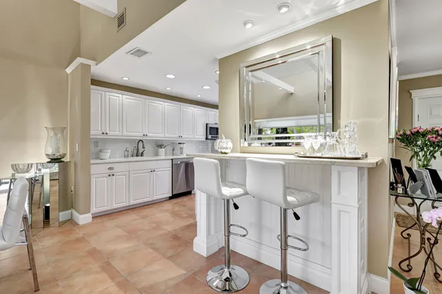 a kitchen with stainless steel appliances granite countertop a sink and dishwasher with white cabinets