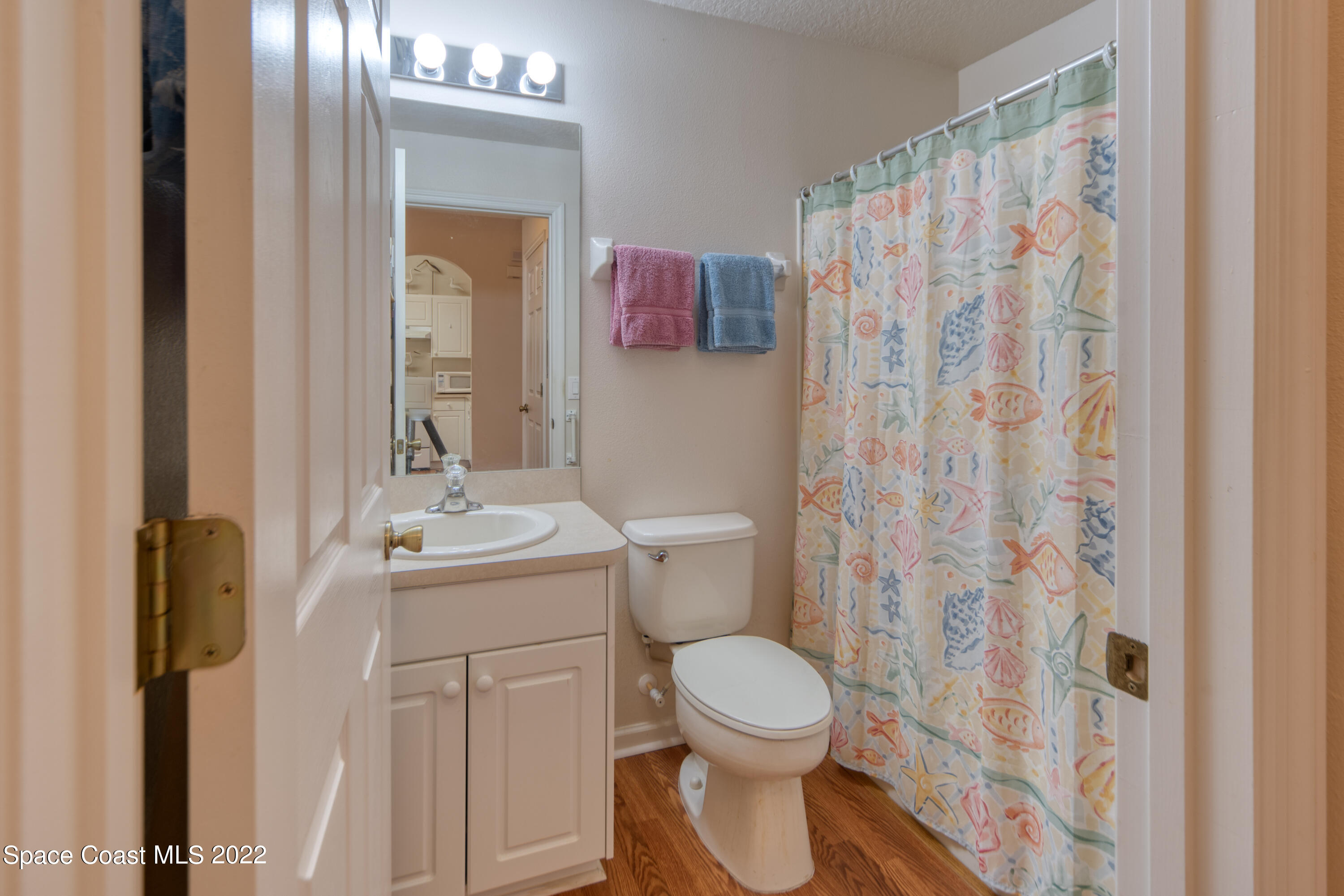 995 Luminary Circle, Unit 103 Melbourne, FL 32901 - Photo 13 of 27 a bathroom with a sink a toilet and shower curtain