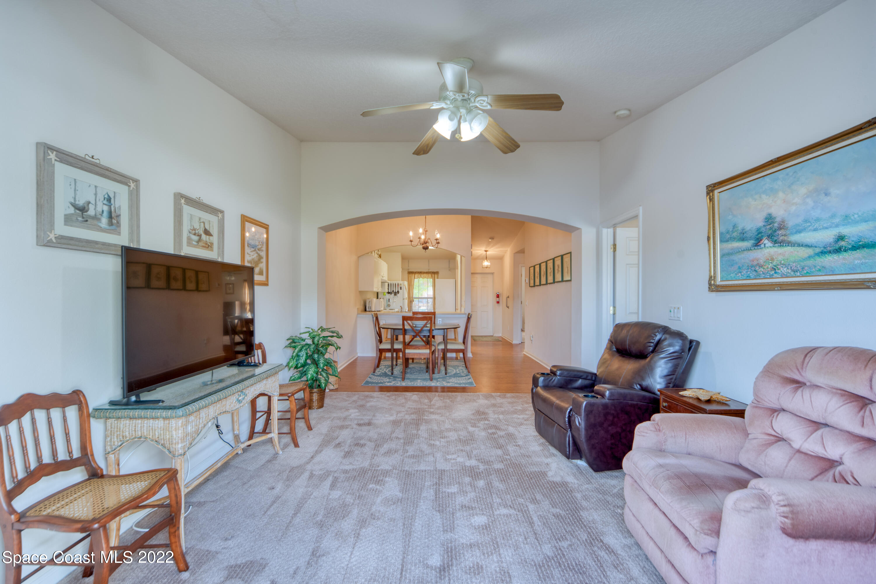 995 Luminary Circle, Unit 103 Melbourne, FL 32901 - Photo 16 of 27 a living room with furniture a flat screen tv and a large window