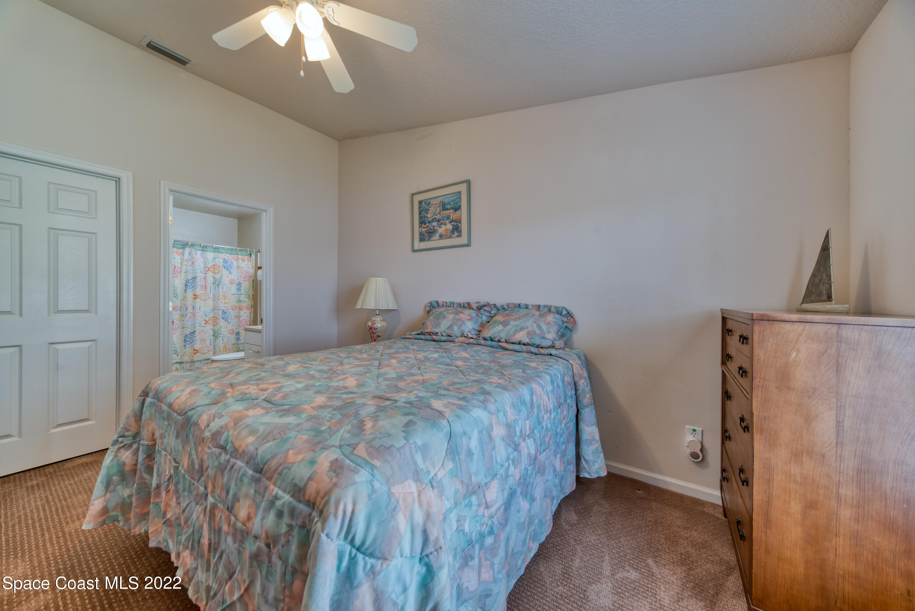 995 Luminary Circle, Unit 103 Melbourne, FL 32901 - Photo 18 of 27 a bedroom with a bed and a chandelier