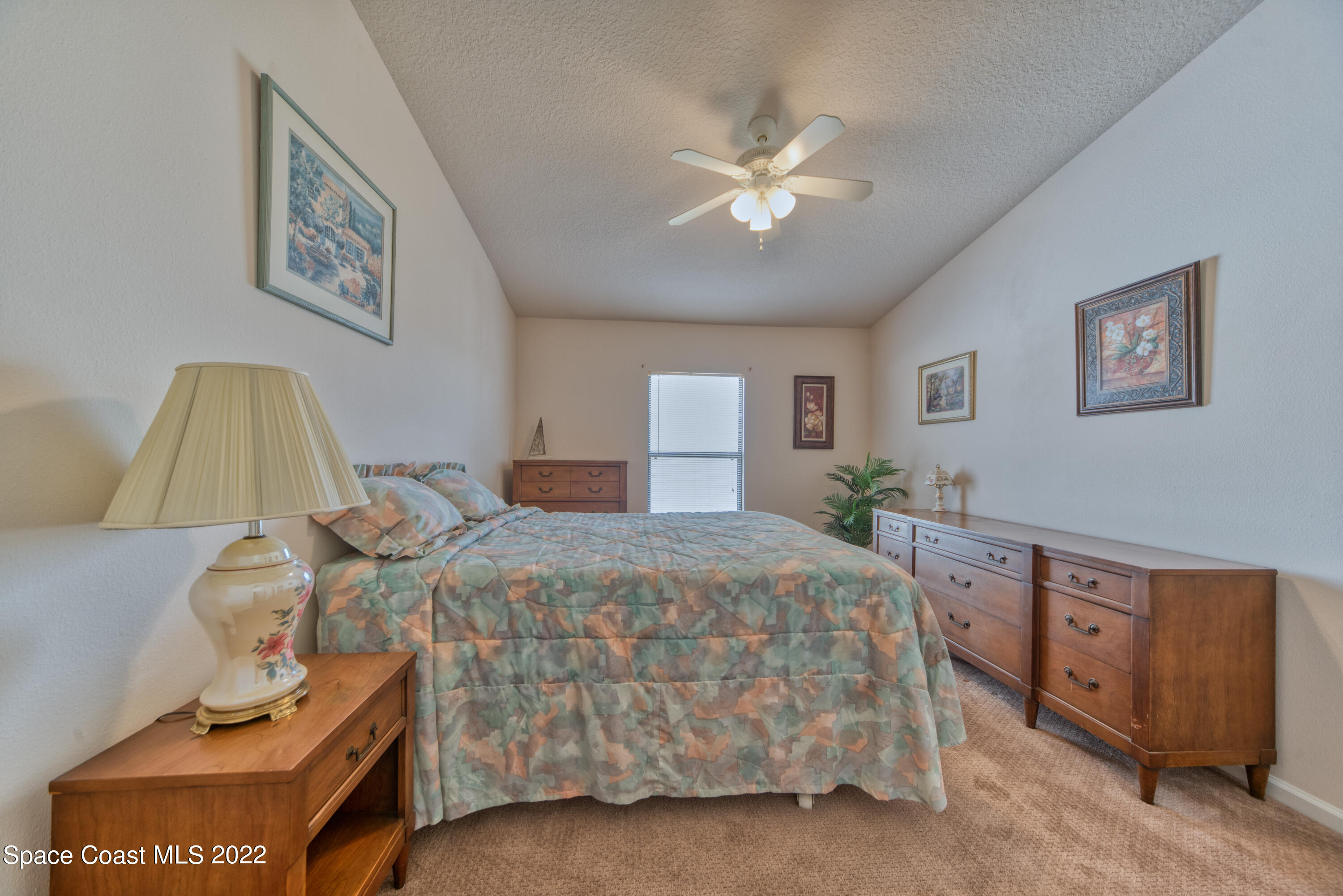 995 Luminary Circle, Unit 103 Melbourne, FL 32901 - Photo 19 of 27 a bedroom with a bed and a chandelier