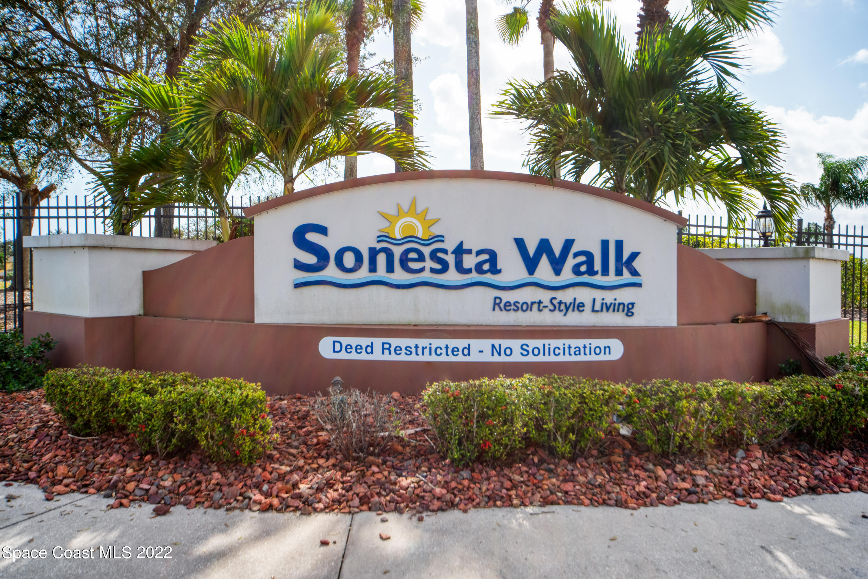 995 Luminary Circle, Unit 103 Melbourne, FL 32901 - Photo 3 of 27 a sign broad in front of flowers
