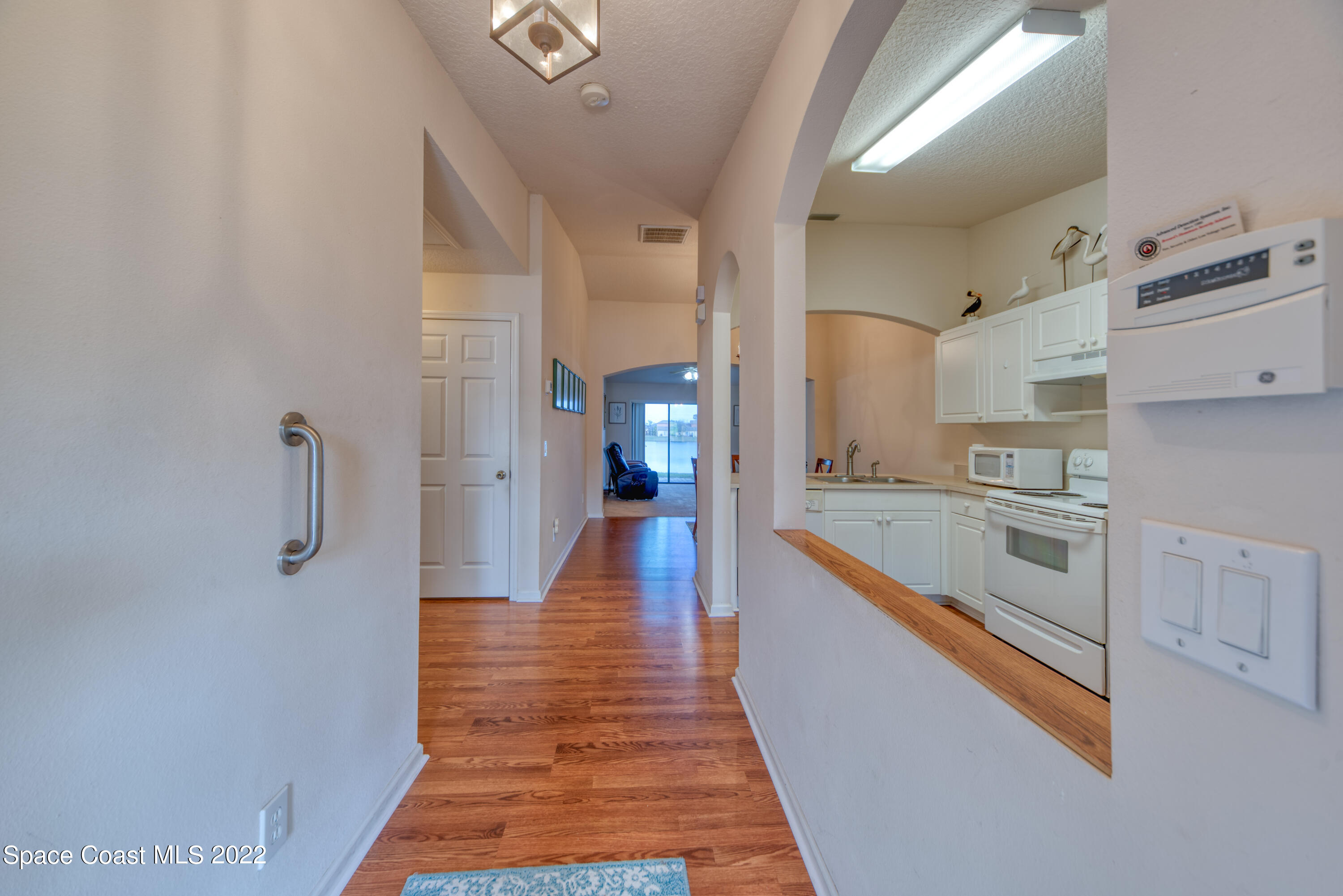 995 Luminary Circle, Unit 103 Melbourne, FL 32901 - Photo 5 of 27 a large kitchen with cabinets and wooden floor