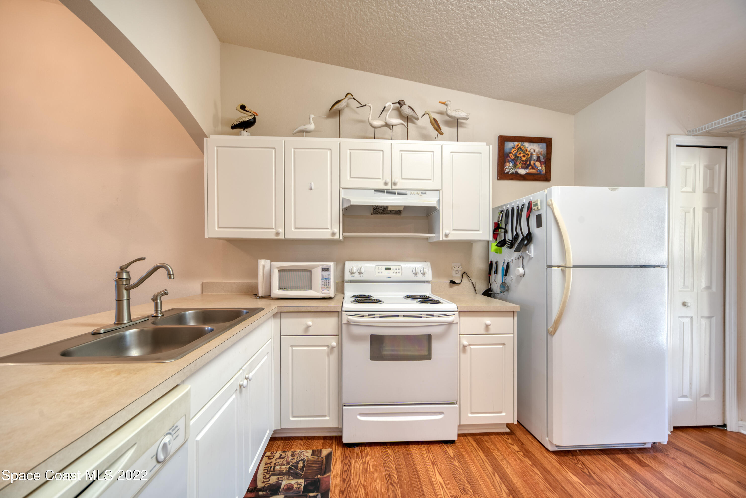 995 Luminary Circle, Unit 103 Melbourne, FL 32901 - Photo 8 of 27 a kitchen with a sink a refrigerator and cabinets