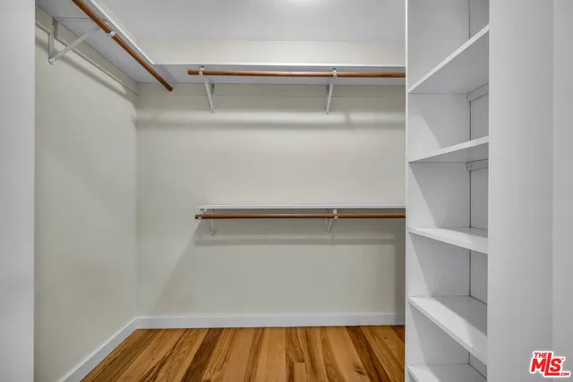 a view of walk in closet with empty racks