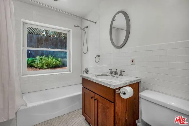 a bathroom with a granite countertop sink a toilet and a bathtub