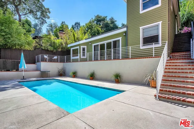 a view of a house with pool and a chairs