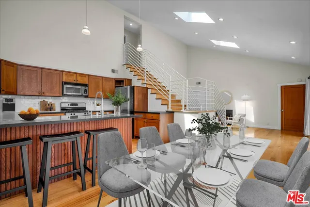 a dining room with furniture a wooden floor and a kitchen view
