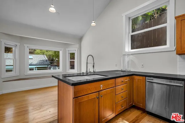 a kitchen with stainless steel appliances granite countertop a sink and cabinets with wooden floor