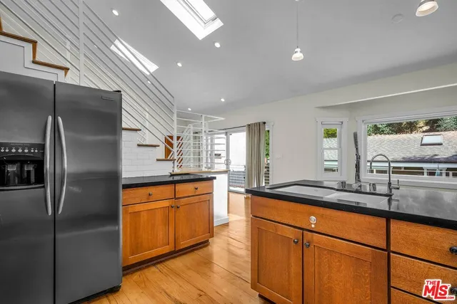 a kitchen with stainless steel appliances granite countertop a sink and a refrigerator