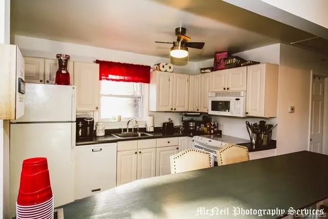 a kitchen with granite countertop a sink a window and stainless steel appliances