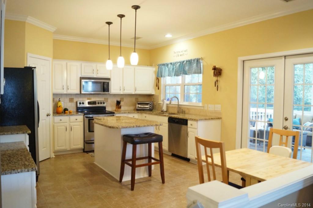 2224 Winthorp Ridge Road Charlotte, NC 28270 - Photo 8 of 24 a kitchen with kitchen island granite countertop a table chairs microwave and sink