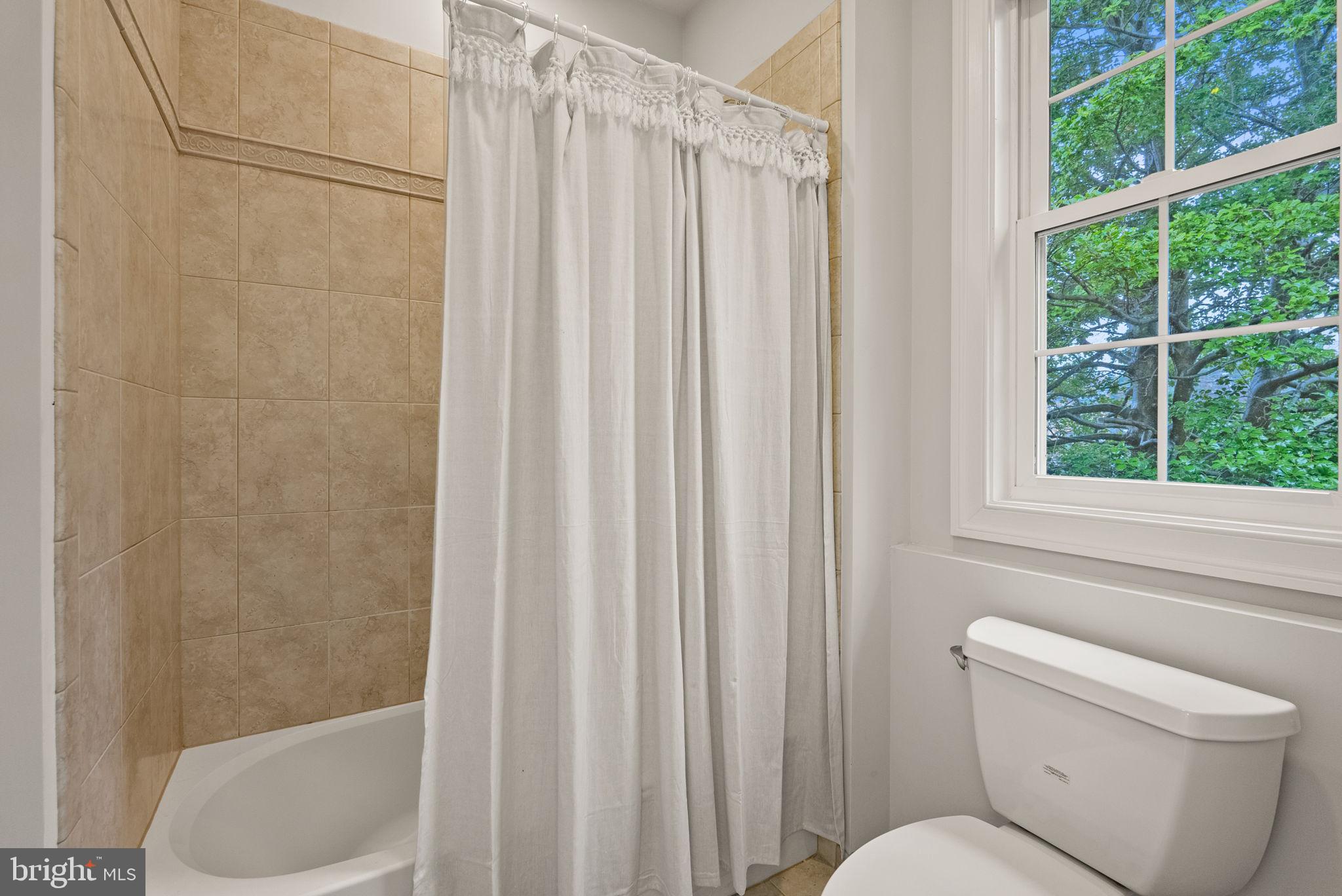8522 Lewinsville Road McLean, VA 22102 - Photo 35 of 51 a bathroom with a toilet and a shower curtain