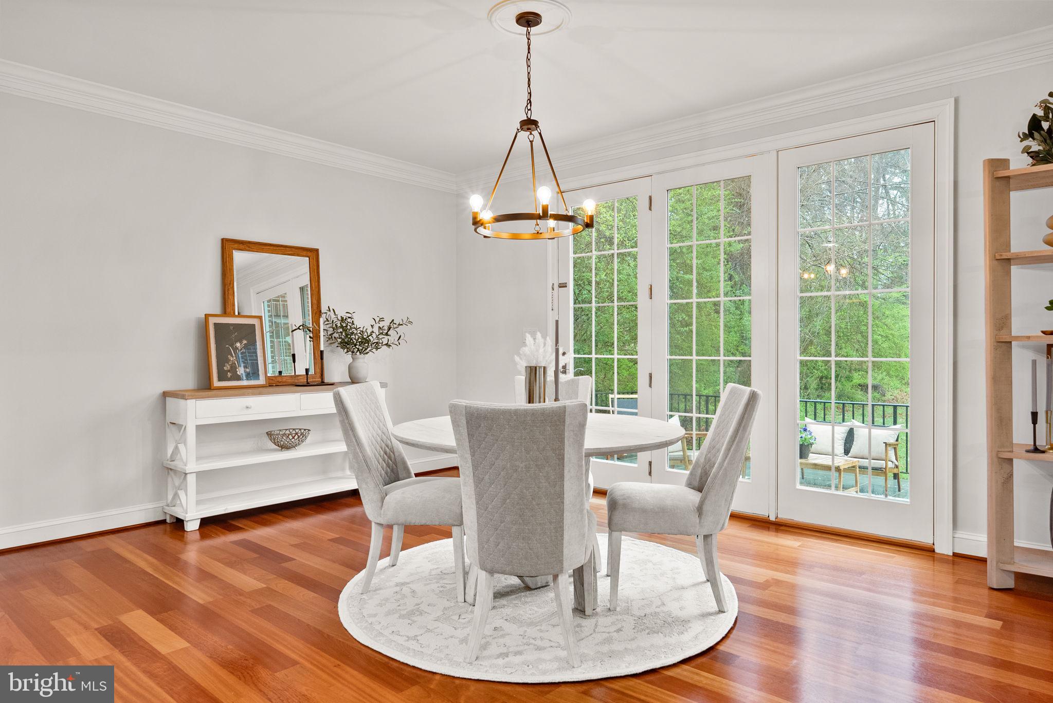 8522 Lewinsville Road McLean, VA 22102 - Photo 5 of 51 a dining room with wooden floor a chandelier a glass table and chairs
