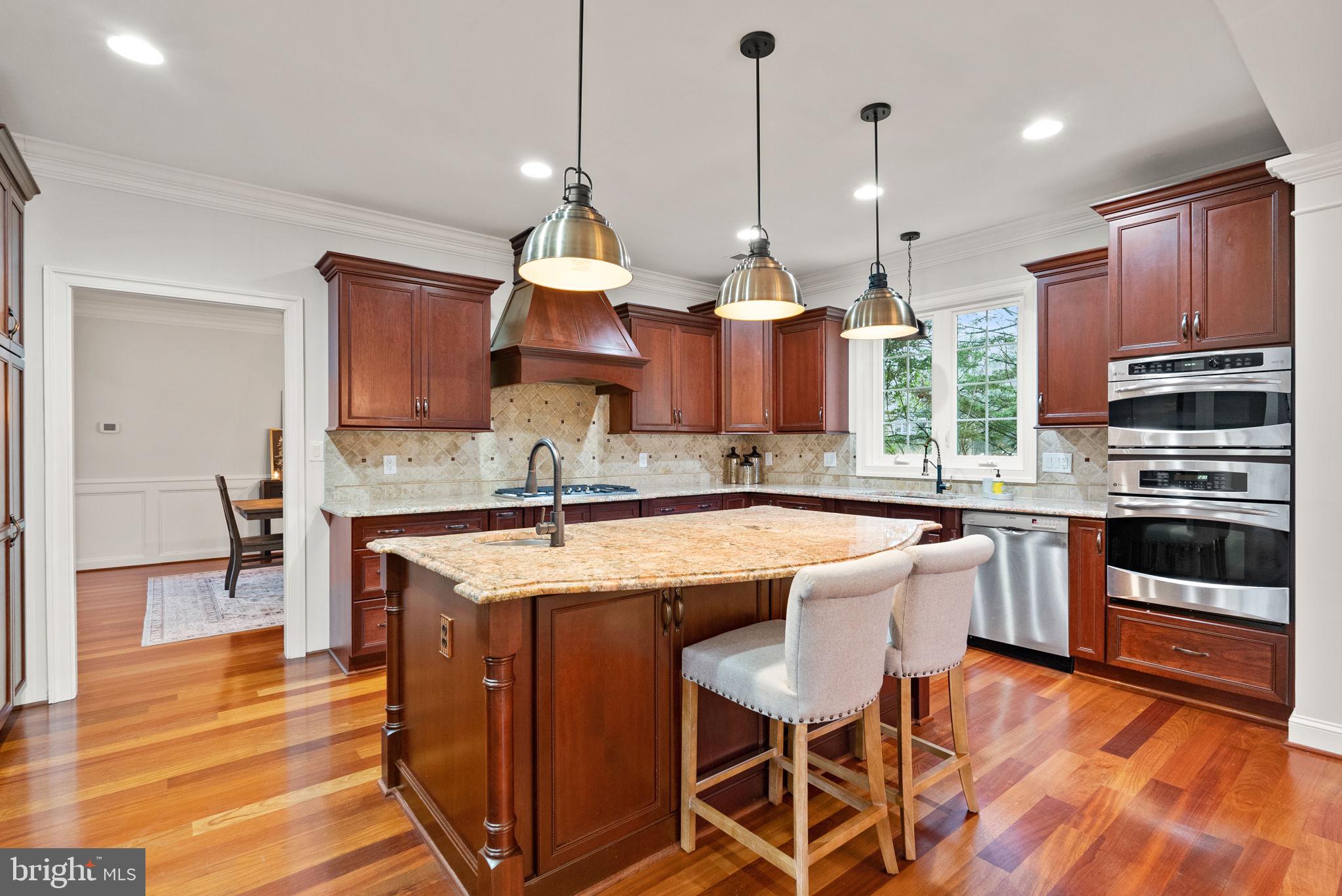 8522 Lewinsville Road McLean, VA 22102 - Photo 6 of 51 a open kitchen with stainless steel appliances granite countertop a stove a sink a oven a dining table and chairs with wooden floor
