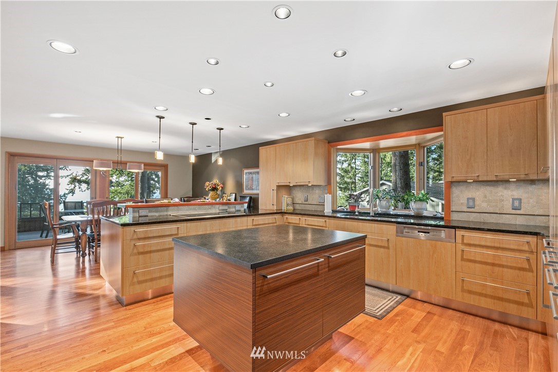 629 Fieldston Road Bellingham, WA 98225 - Photo 7 of 25 a large kitchen with kitchen island a sink a stove a dining table and chairs