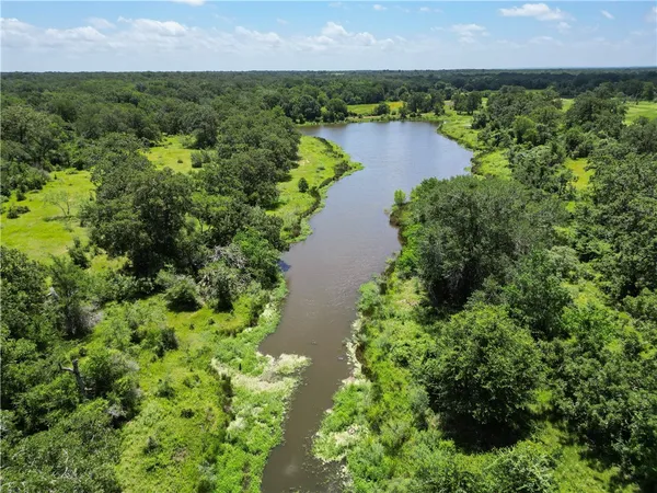 an aerial view of city and river surrounded with trees