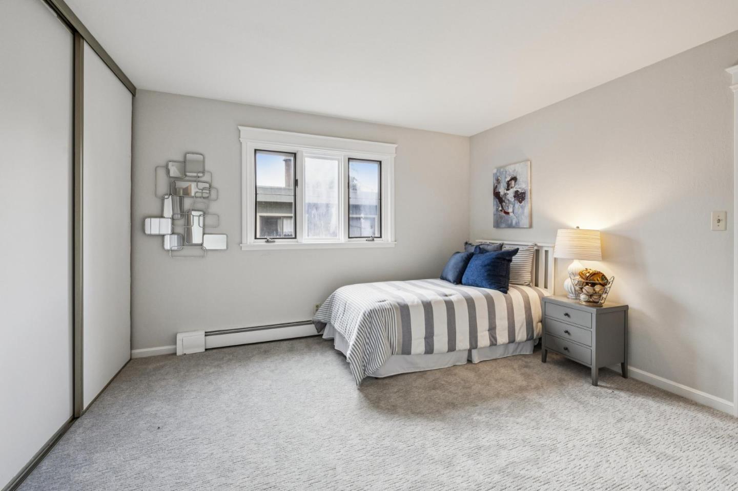 712 Crossway Road Burlingame, CA 94010 - Photo 68 of 90 a spacious bedroom with a bed and wooden floor