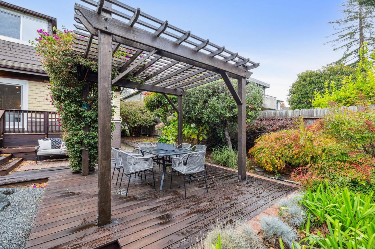 712 Crossway Road Burlingame, CA 94010 - Photo 83 of 90 a view of a patio with table and chairs potted plants with wooden floor and fence