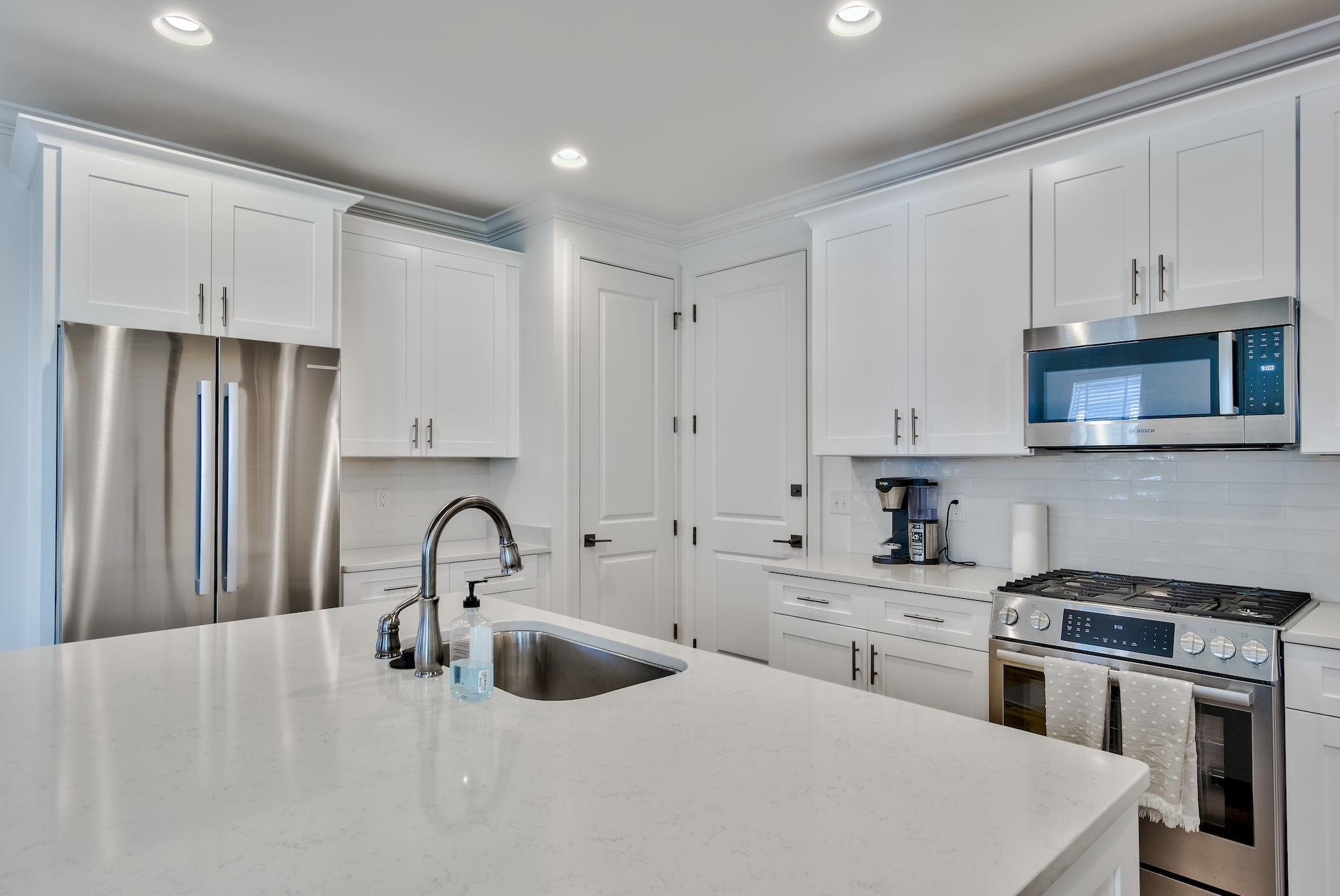 25 Cambium Court Watersound, FL 32461 - Photo 17 of 23 a kitchen with stainless steel appliances a sink a stove and a refrigerator