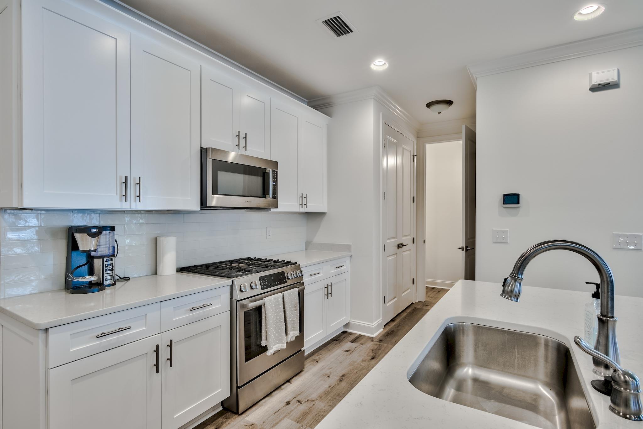 25 Cambium Court Watersound, FL 32461 - Photo 3 of 23 a kitchen with white cabinets and stainless steel appliances