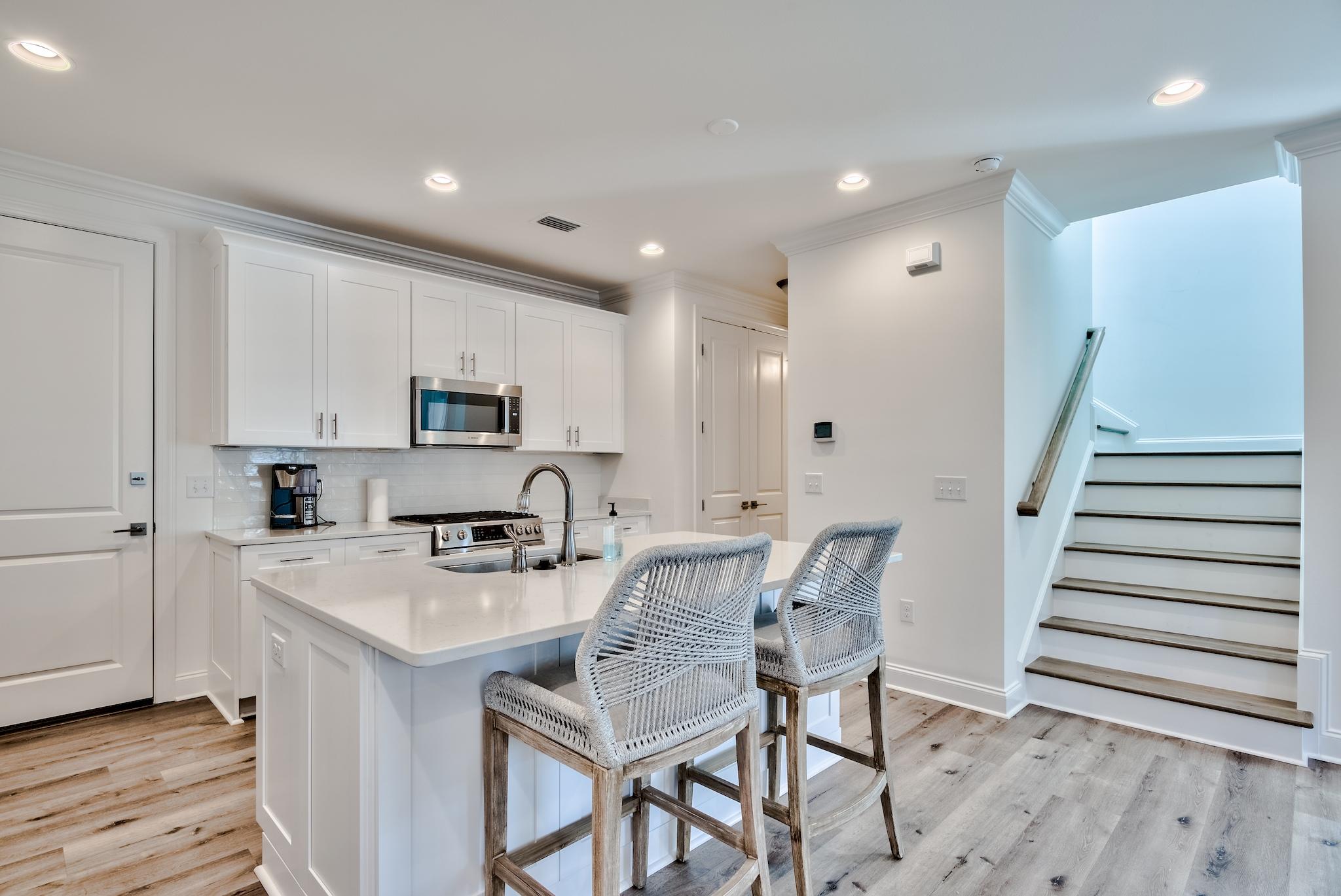 25 Cambium Court Watersound, FL 32461 - Photo 4 of 23 a kitchen with granite countertop a table chairs microwave and cabinets