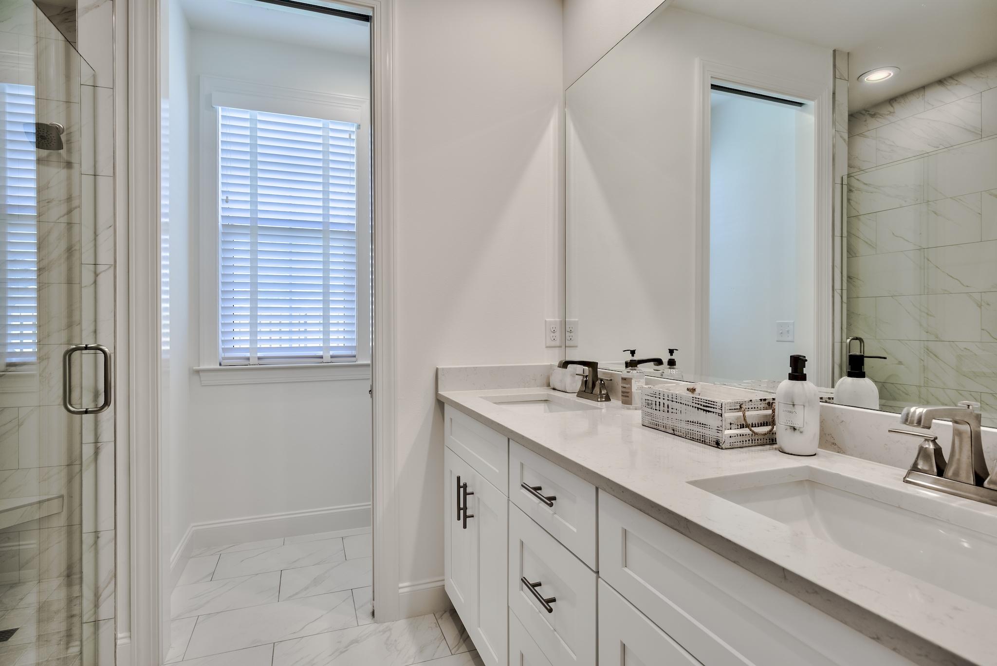 25 Cambium Court Watersound, FL 32461 - Photo 10 of 23 a bathroom with a double vanity sink a mirror and a shower