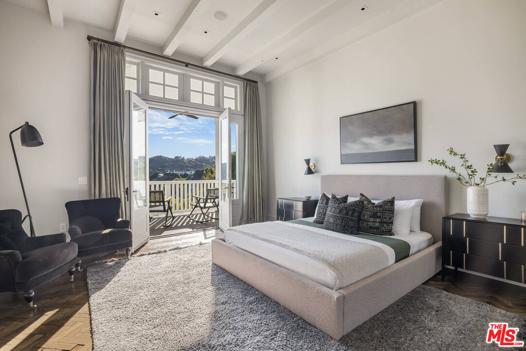 9779 Oak Pass Road Beverly Hills, CA 90210 - Photo 24 of 43 a bedroom with a bed and glass window